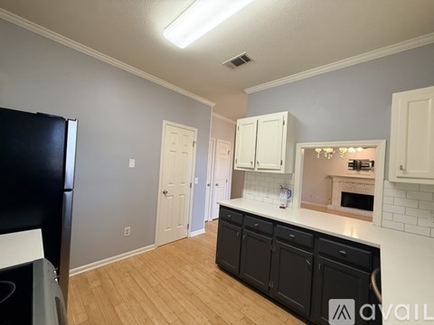 A kitchen with black cabinets and a white stove top oven.