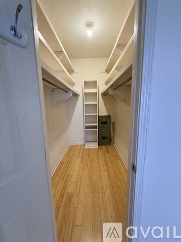 A hallway with a staircase leading to a bedroom.