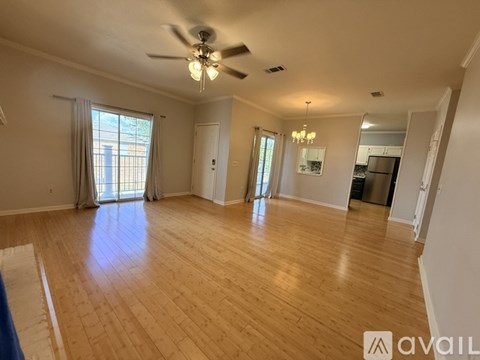 A spacious room with wooden flooring and a ceiling fan.