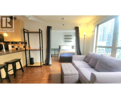 A living room with a grey couch and a black and white checkered bar.