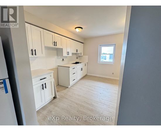 A kitchen with white cabinets and a window.