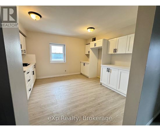 A room with white cabinets and a window.