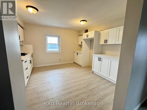 A room with white cabinets and a window.