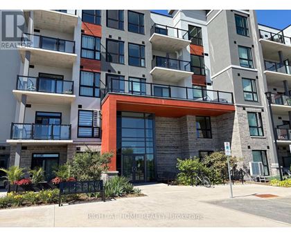 A multi-story apartment building with a red entrance and balconies.