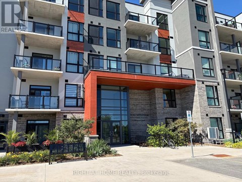 A multi-story apartment building with a red entrance and balconies.