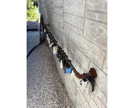 A row of padlocks are attached to a wall.
