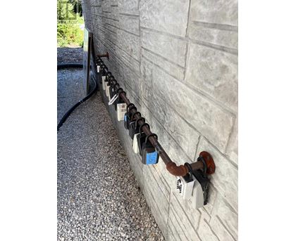 A row of padlocks are attached to a wall.