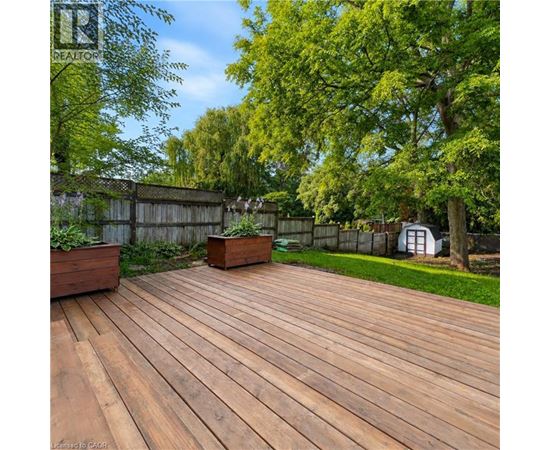 A wooden deck with a fence and trees in the background.