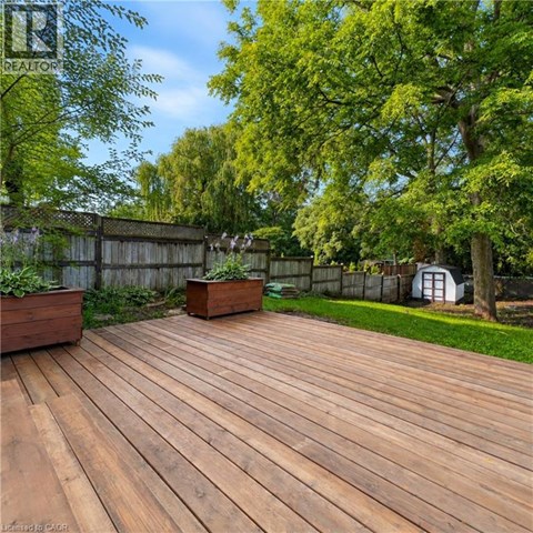 A wooden deck with a fence and trees in the background.