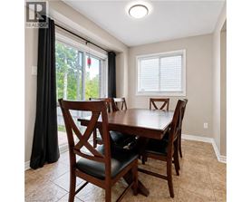 A dining room with a wooden table and chairs.