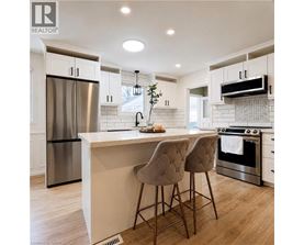 A modern kitchen with a large island and bar stools.