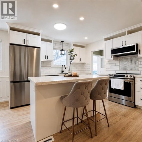 A modern kitchen with a large island and bar stools.