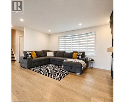 A living room with a grey sectional sofa and a patterned rug.