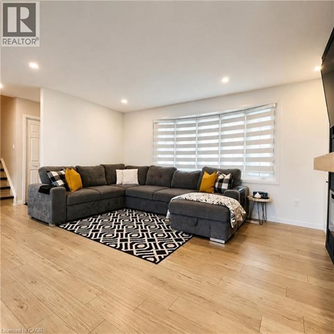 A living room with a grey sectional sofa and a patterned rug.