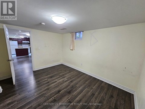 A room with wooden flooring and a white ceiling.