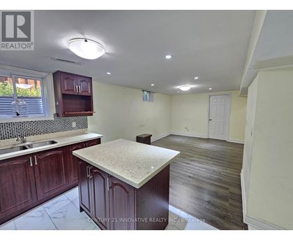 A kitchen with dark wood cabinets and a granite countertop.