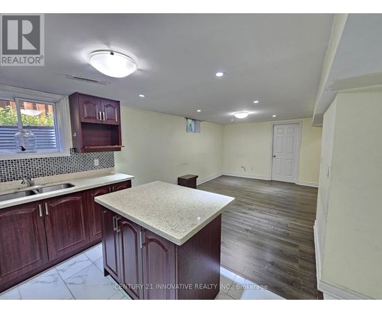 A kitchen with dark wood cabinets and a granite countertop.