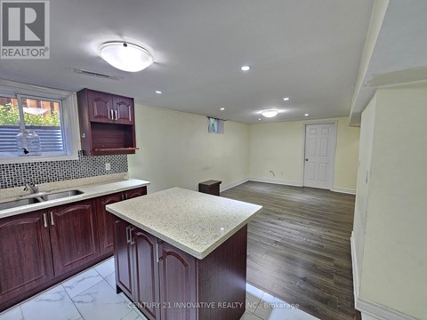 A kitchen with dark wood cabinets and a granite countertop.