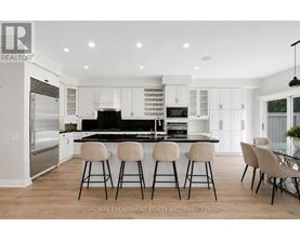 A modern kitchen with white cabinets and a black island.