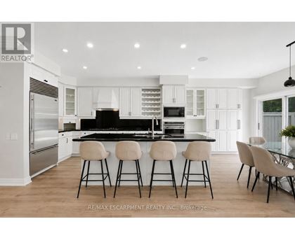 A modern kitchen with white cabinets and a black island.