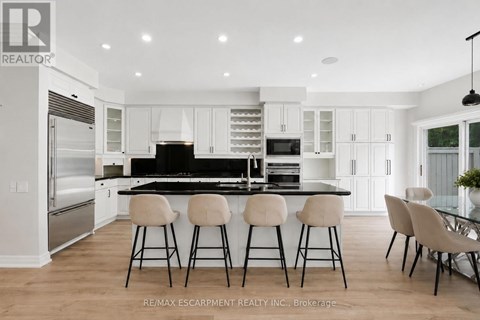 A modern kitchen with white cabinets and a black island.