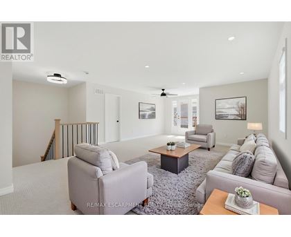 A living room with a grey sofa, a grey rug, a wooden coffee table, and a painting on the wall.