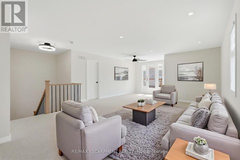 A living room with a grey sofa, a grey rug, a wooden coffee table, and a painting on the wall.