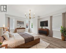 A bedroom with a large bed, a chandelier, and a flat-screen TV.
