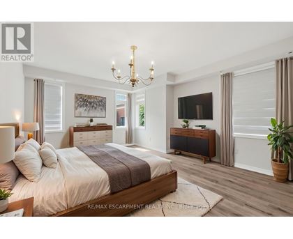 A bedroom with a large bed, a chandelier, and a flat-screen TV.