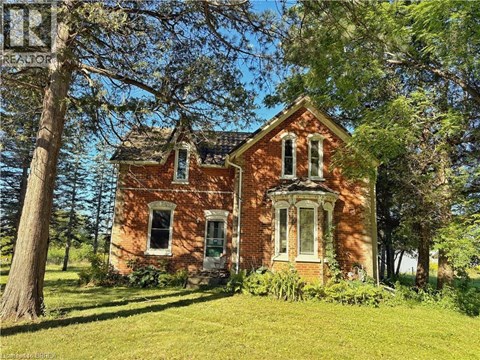 A red brick house with a white door and windows.