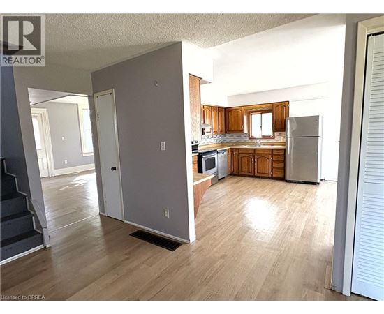 A kitchen with wooden cabinets and a refrigerator.