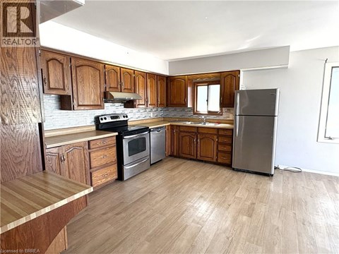 A kitchen with wooden cabinets and a refrigerator.