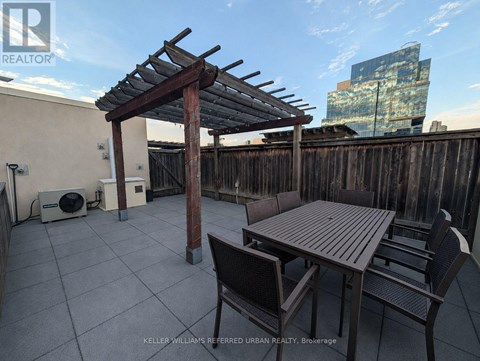 A patio with a table and chairs under a pergola.