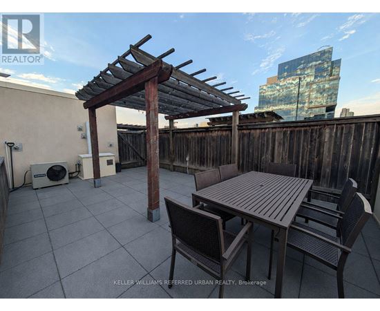 A patio with a table and chairs under a pergola.