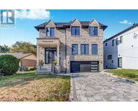A large, modern house with a stone facade and a large front yard.