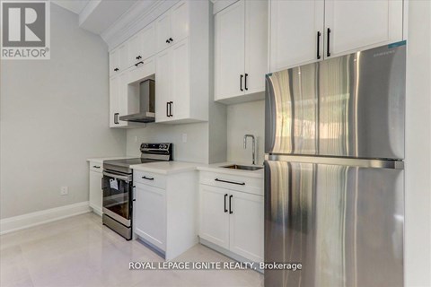 A kitchen with white cabinets and a stainless steel refrigerator.