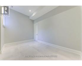 A spacious room with white walls and a white door.