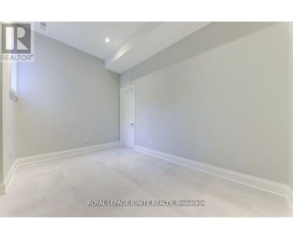 A spacious room with white walls and a white door.