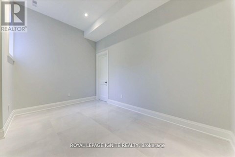A spacious room with white walls and a white door.