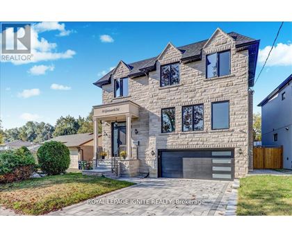 A large, modern house with a stone facade and a garage is for sale.