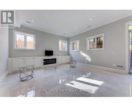 A spacious living room with a glass coffee table in the middle.