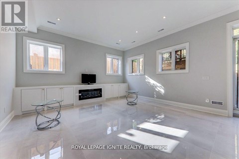 A spacious living room with a glass coffee table in the middle.