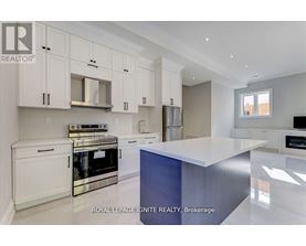 A modern kitchen with white cabinets and stainless steel appliances.
