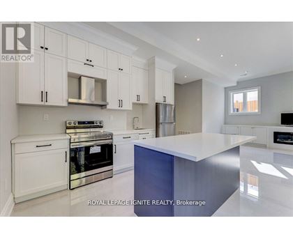 A modern kitchen with white cabinets and stainless steel appliances.