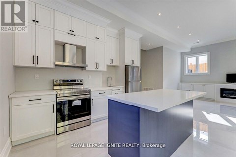 A modern kitchen with white cabinets and stainless steel appliances.