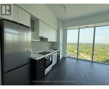 A kitchen with a refrigerator, sink, and stove top oven.