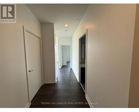 A hallway with a white door on the left and a black door on the right.