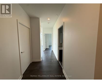 A hallway with a white door on the left and a black door on the right.