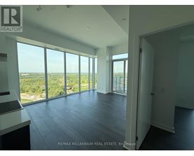 A spacious room with large windows overlooking a landscape.
