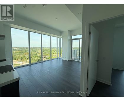 A spacious room with large windows overlooking a landscape.
